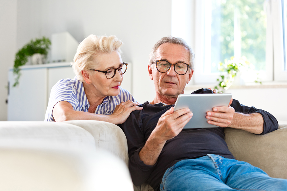 elderly couple looks with concern at a tablet